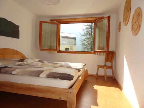 Schlafzimmer mit einem Bett und einem Fenster in der Unterkunft Crusch 32 in Samedan