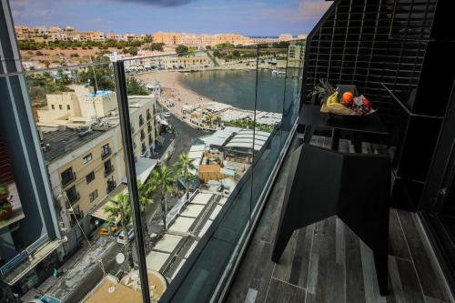 a view of a beach from a building with a bowl of fruit at H Hotel & SPA - Adults Only in St Julian's