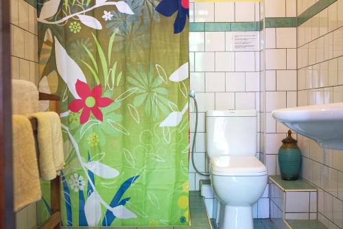 a bathroom with a toilet and a flower shower curtain at Villa Lucky Star in Tangalle