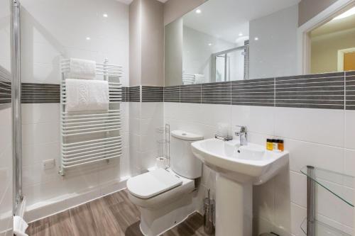 een witte badkamer met een toilet en een wastafel bij House of Fisher - City Wall House in Reading