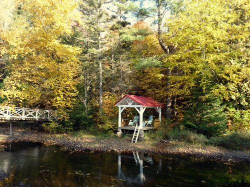 a gazebo next to a body of water at Chalet Le Semeur in Saint Elie