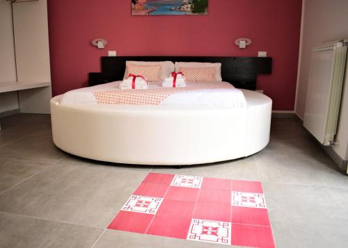 B&B Vietri 360 في فيتري: غرفة نوم مع سرير أبيض كبير مع جدران وردية