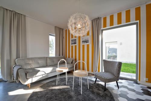 a living room with a couch and chairs and a chandelier at KOMFORTOWE DOMKI Brzozowa Przystań nad morzem we Władysławowie in Władysławowo