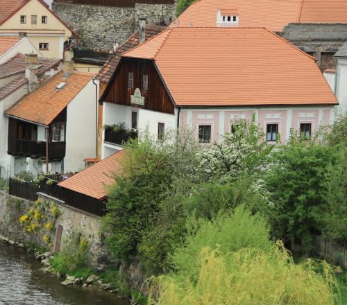 a building with an orange roof next to a river at Pension Plešivecká 119 in Český Krumlov