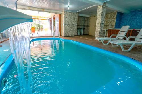 una piscina con una fuente de agua en Sky Valle Hotel en Gramado