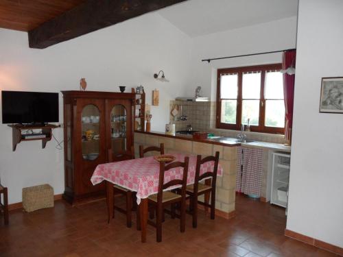 eine Küche mit einem Tisch und Stühlen sowie einem TV in der Unterkunft Appartamento TRE QUERCE di Guerrini Gian Carlo in Sorano