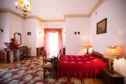 a bedroom with a red bed and a table at U Schabińskiej - Pałac w Gorlicach in Gorlice