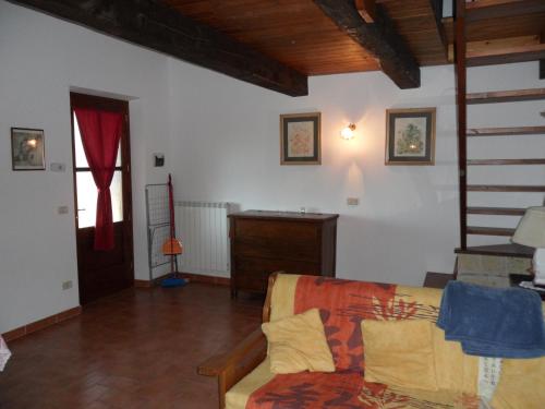ein Wohnzimmer mit einem Sofa und einer Treppe in der Unterkunft Appartamento TRE QUERCE di Guerrini Gian Carlo in Sorano