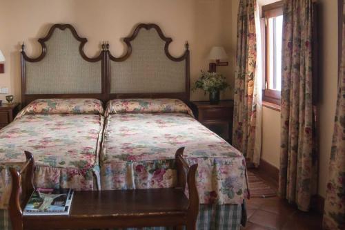 a bedroom with a bed and a table with a bedspread at Hacienda de Orán in Utrera