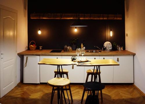 a kitchen with two tables and two stools at #Pobega heritage - self check-in in Timişoara