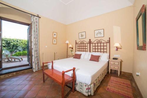 a bedroom with a bed and a large window at Hacienda de Orán in Utrera
