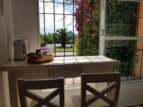 a table with two chairs in front of a window at Costa de Tigre, habitaciones in Tigre