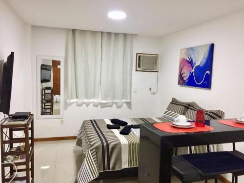 een woonkamer met een bed en een tafel in een kamer bij Studio Botafogo Beach in Rio de Janeiro