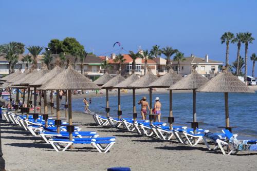a group of chairs and umbrellas on a beach at Destinos De Sol Los Alcazares - Montepío Minería in Los Alcázares