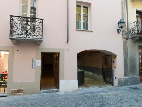 a white building with a balcony and a door at Maison Croix de Ville in Aosta