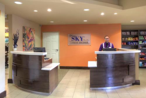 a man standing behind a counter in a store at staySky Suites I-Drive Orlando Near Universal in Orlando