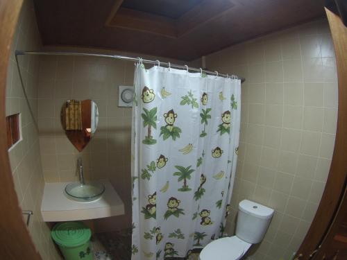a bathroom with a shower curtain with monkeys on it at Jing Jo Boutique Bungalow in Sam Roi Yot