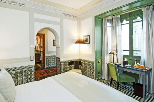 a hotel room with a bed and a desk at Palais Faraj Suites & Spa in Fès