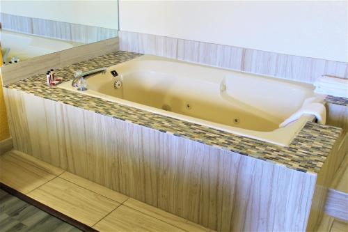 a bath tub in a bathroom with a counter top at Super 8 by Wyndham Ft Stockton in Fort Stockton