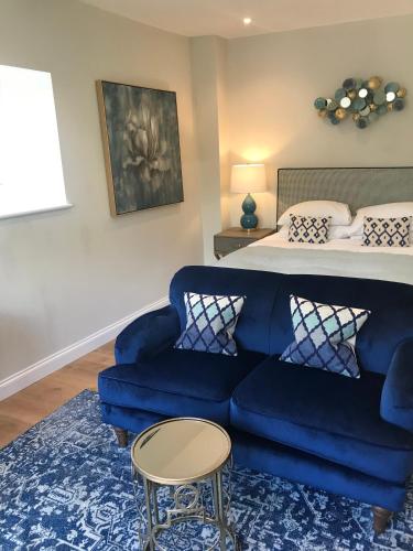 a bedroom with a blue couch and a bed at The Ormond At Tetbury in Tetbury