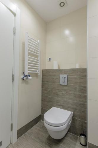 a bathroom with a white toilet and a window at Sava Smart Apartment in Belgrade