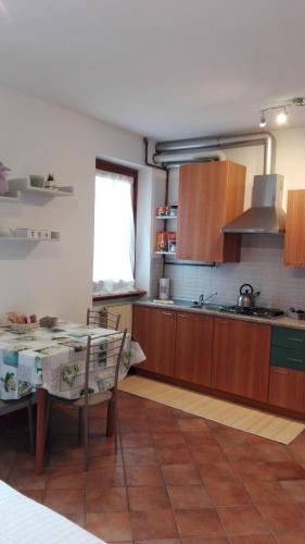 a kitchen with wooden cabinets and a table in it at Sweet Home Casa Vacanze "La Terrazza" in Rovetta