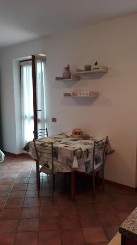 a table and chairs in a room with a window at Sweet Home Casa Vacanze "La Terrazza" in Rovetta