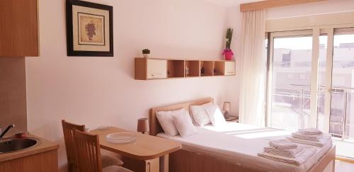 a bedroom with a bed and a table and a window at Olimp Lux II in Budva