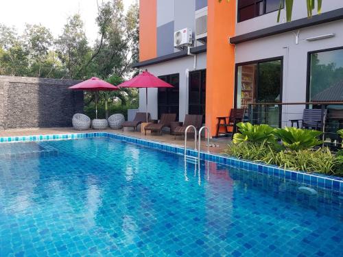 a swimming pool in front of a building at Bangkok Boutique Resort Rangsit in Pathum Thani