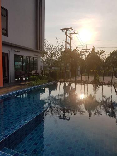 a swimming pool with the sun reflecting in the water at Bangkok Boutique Resort Rangsit in Pathum Thani
