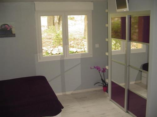 a room with two windows and a table at La Maison St Gervais in Saint-Gervais