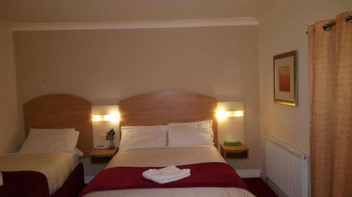 
a hotel room with two beds and two lamps at Lloyds of Chester in Chester
