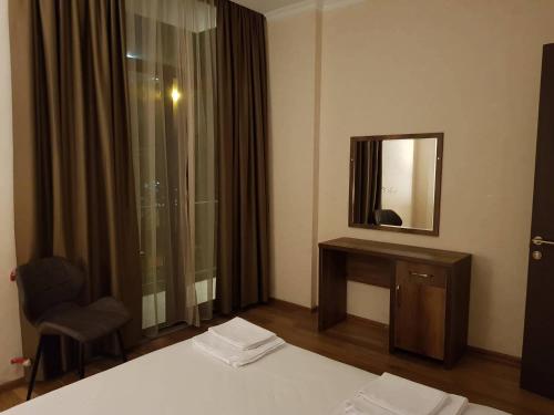 a hotel room with a bed and a mirror at Hotel Absolut in Batumi