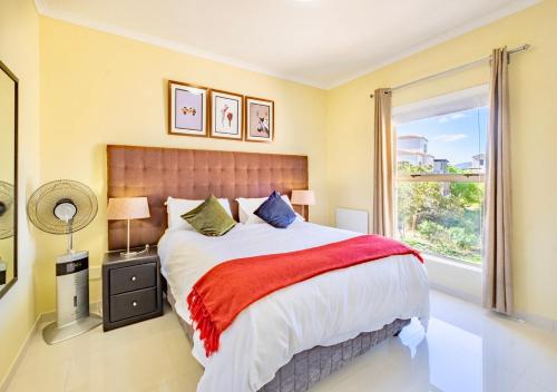 a bedroom with a large bed and a window at Bougain Villas in Cape Town