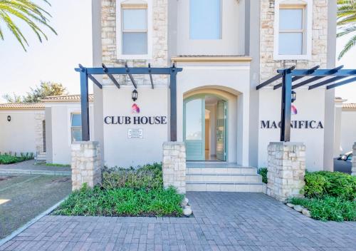 a white house with a sign for a club house at Bougain Villas in Cape Town