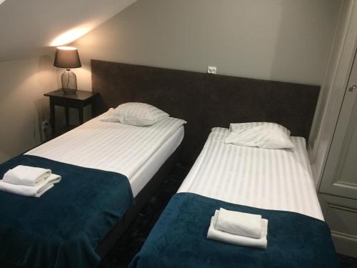 two beds sitting next to each other in a room at Pensjonat Retro in Łomża