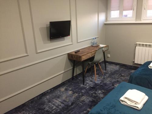 a room with a desk and a tv on a wall at Pensjonat Retro in Łomża