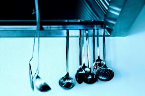 a group of kitchen utensils hanging from a rack at Pension Apartments Klotznerhof in Schenna