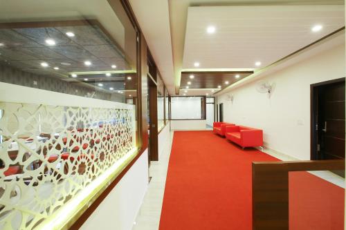 a hallway with red chairs and a red carpet at MAZUS INN in Vythiri