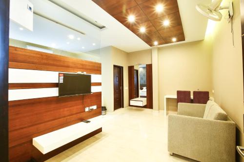 a living room with a tv and a couch at MAZUS INN in Vythiri