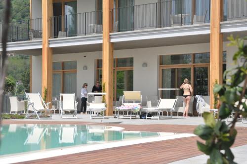 a group of people standing on a patio next to a pool at Tullio Hotel in Gravedona