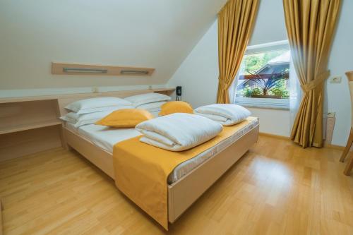 1 Schlafzimmer mit 2 Betten, gelben Kissen und einem Fenster in der Unterkunft Villa Nena in Kranjska Gora