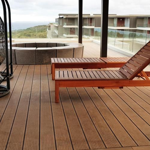 a wooden bench sitting on the deck of a building at No 2 Heleza Blvd Sibaya, Oceandune, Umhlanga Durban in Umdloti