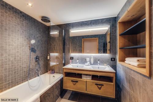 a bathroom with a tub and a sink and a shower at Hôtel Avancher in Val-d'Isère