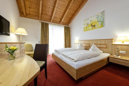 a bedroom with a bed and a desk and a table at Unterwirt in Waging am See