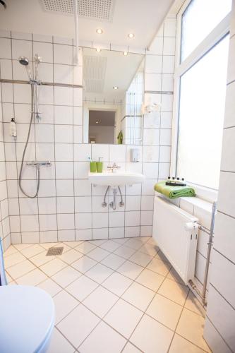 a bathroom with a sink and a shower at Go Hotel Ansgar in Copenhagen