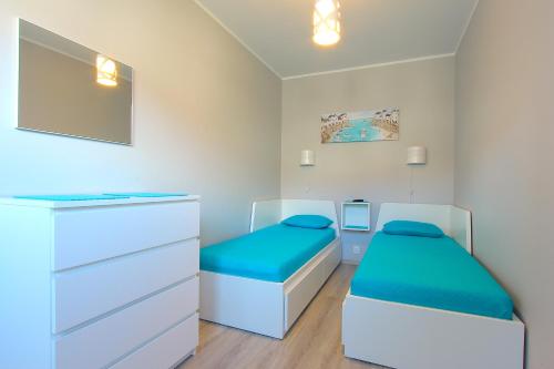 ダルウフコにあるBaltic Korona Apartamenty E07のベッド2台と鏡が備わる客室です。