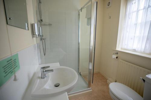 a bathroom with a sink and a shower and a toilet at The Barford Inn in Salisbury