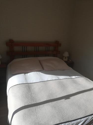 a bedroom with a white bed with a wooden headboard at Apart Hotel Gran Pacifico in La Serena