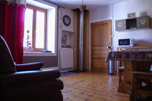 a living room with a couch and a window at Au Coeur du Lapidaire in Septmoncel